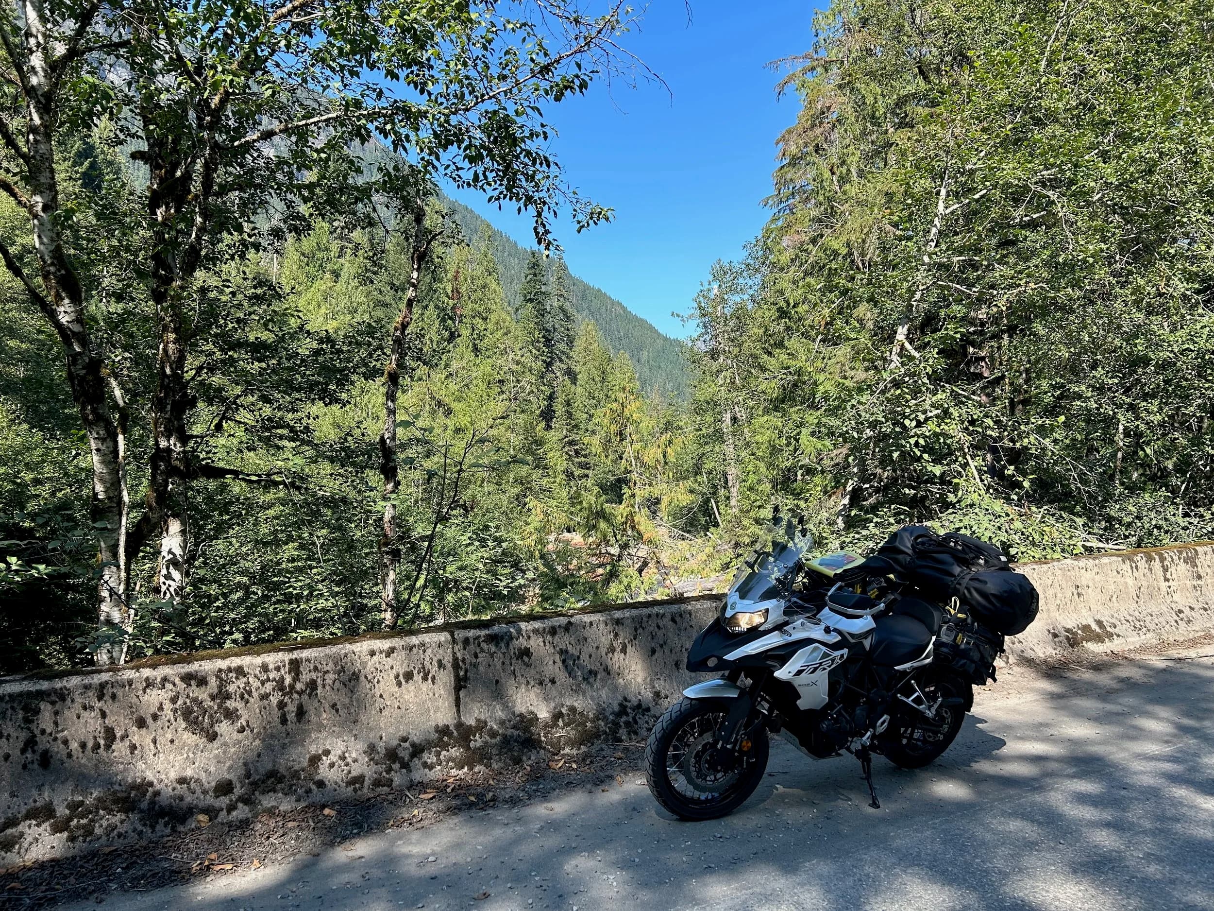 Trip Report: NW National Parks Loop
I left my job recently to take a much needed sabbatical and figure out what I’m doing next. A few weeks after my last day at work I embarked on what was to be a three week tour of NW-ish National Parks from Portland, to include Olympic, North Cascades, Glacier, Yellowstone, Grand Teton, Craters of the Moon, Lassen Volcanic, and Crater Lake.
I ended up missing Grand Tetons due to weather and I had to cut the trip short before I got to Lassen (family medical issue), so Lassen and Crater Lake remain unvisited.
Trip Dates: Sept 3 - Sept 16 (13 days)
Total Travel Miles: 3478 (does not include local miles for store runs, etc.)
Total Gallons of Gas Used: 82
Equipment: 2021 Benelli TRK502X Gaia GPS & Google Maps running on Sonim XP8 rugged Android phoneButler Motorcycle Maps (paper maps of best M/C roads in the country) iPhone 14 (main camera) Akaso Brave 7 helmet-mounted adventure camera Spot X satellite communicator and tracker Wolfman Luggage WP waterproof tank bag and saddle bags (no longer available) Watershed Colorado dry bag duffel (across the pillion seat) Kriega US-5 Drypack (tail bag) Kriega 3L hydration backpack (strapped to duffel, not worn)Marmot Ajax 2 tent Nemo hydrophobic down sleeping bag (non-mummy)Helinox ultralight cot MSR WhisperLite International stove
(Purchased in 1991 for my first moto trip: Detroit, MI to San Diego and back on an XT250)Gossamer Gear Bare Boxer bear-proof food canisters (two - one in each saddle bag)
Day 1 - Olympic National Park Date: Tuesday 9/3/2024
Destination: South Beach Campground, Olympic National Park
Travel Time: 4h 24m
Miles: 213Notes:
Planned to head west to Astoria then north from there, but left later than expected so headed up I-5 to US 12. I’ve driven/ridden that stretch of I-5 hundreds of times (starting in 1993). It’s boring and I hate it.
South Beach CG is first-come-first-served. I didn’t have issue getting a site. There is a long, tight loop of sites along the coastline, but I chose one of the sites further back near the bathrooms due to wind concerns. The bathroom building provided a sort of wind shelter for my site.
I used the heated grips on this leg; it was pretty chilly along the coast in the Olympic Peninsula. I almost didn’t install them, thinking I was being paranoid about the cold. I ended up using them a lot.
Day 2 - Ferry to Seattle / Burien Date: Wednesday 9/4/2024
Destination: Friend’s house in Burien, WA
Travel Time: 7h 30m
Miles: 199
Notes:
Slept well (thanks to Advil PM). I’ve not been sleeping well for more than a year. I’m really hoping to reset my sleep patterns with this trip. A good night’s sleep is one of my great joys and I feel like I’ve been robbed of that pleasure.
Used my Aeropress this morning for the first time ever. I’m hooked.
Headed up along US 101 through Port Angeles and then down to the Southworth ferry terminal near Port Orchard. Ferried across to Fauntleroy, which is just a few miles north my friend’s house in Burien. I’m always surprised at how long it takes to get from the Olympic Peninsula to the east side of Puget Sound (Seattle, etc.). With the ferry crossing (I love ferries) it took seven and a half hours to go 200 miles.
Discovered at my first stop of the day (just up 101 at the Kalaloch Campground, stopped to refill water) that the battery is quite weak and won’t start the bike if you leave the ignition on for even two minutes without the motor running. This would become a theme for the next few days. Fortunately, I have a jumper box and a permanent jump harness wired to the battery so jump starts are a quick operation.
Had a good evening with old friends.
Day 3 - North Cascades via Mountain Loop RoadDate: Thursday 9/5/2024
Destination: Newhalem Campground, North Cascades National Park
Travel Time: 4h 30m
Miles: 146Notes:
Slept well, on the couch. No pills needed.
I realized yesterday that my summer riding gloves (Rev’It Dune) were a size (or two) too small. Rev’It gloves fit really tight and I feel like I can never get it quite right. And yet, I love them. So, I stopped at a Cycle Gear in Bellevue to pick up something summer weight (Dirt 3) that fit better. They’re better, but maybe still one size too small. Such is life.
From Bellevue, I rode north and took the Mountain Loop Hwy then on up north to North Cascades. It was a hot ride. Still summer.
A small section of the Mountain Loop Road is dirt/gravel, which I didn’t realize. No biggie. Was just surprised (clearly I didn’t study my maps closely enough). When riding solo on a bike that weighs over 500 lbs., I tend to avoid planning much off-pavement riding. That’s what my DR-Z is for.
Day 4 - Newport, Washington via Winthrop Date: Friday 9/6/2024
Destination: Golden Spur Motor Inn, Newport, Washington
Travel Time: 8h
Miles: 308
Notes:
Slept just ok, even with Advil PM.
Pretty ride through North Cascades National Park and Colville National Forest. Didn’t do any backroads or hikes. Discovered (new to me) the town of Winthrop. Stopped for coffee at Sheri’s and resupplied on freeze-dried food at Cascades Outdoor Store.
The town of Newport is almost nothing, but, inexplicably, there’s an amazing restaurant (Brownell’s Place). Had dinner and a few ciders. Met and chatted with the owner/chef (she’s great). Listened to some live music. Then back to the motel.
Day 5 - New Battery in Kalispell Date: Saturday 9/7/2024
Destination: West Glacier KOA, West Glacier, MT
Travel Time: 8h 7m
Miles: 293
Notes:
Slept well on motel bed (on sleeping bag, not in the sheets). Another hot one.
Discovered that the water pump seal leaks oil. A quick post in the TRK Facebook group revealed that this is a common problem on this bike, and and easy fix. It’s apparently just a bad o-ring.
Battery has been getting continuously worse, and now requires I jump start the bike about every other start. Google Maps to the rescue: directions to the Batteries Plus in Kalispell, please. They don’t have an Odyssey AGM in the right size; the Duracell will have to do. (It’s been great.)
I set up camp at the West Glacier KOA, which will be my base for a few days. KOAs are their own little world. Very strange. Not really my thing, but the on-site laundry was handy.
After setting up camp I opened a cider and used the iPad to book a vehicle reservation for the next day to ride Going to the Sun Road, which I really wanted to do.
Day 6 - Going to the Sun RoadDate: Sunday 9/8/2024
Destination: Local Ride: West Glacier, Going to the Sun Road, Saint Mary, East Glacier
Travel Time: 5h 35m
Miles: 142Notes:
Quick breakfast and gas up in West Glacier before entering Going to the Sun Road.
Going to the Sun Road was stunning. This was the first point in the trip where I had tingles and was giddy at what I was seeing.
Took a very short hike along Saint Mary Lake. Again, I was beside myself with the beauty.
Lunch at the general store in Kiowa.
The rest of the ride back after East Glacier was meh, but I just kept thinking about how amazing what I’d seen in the morning had been.
Dinner at the KOA. Tacos from a cart (ok / not great, and a very weird guacamole) and a few glasses of wine from another cart. I asked about the guac and it turns out they make it in a food processor. Come on, people.
Day 7 - Ride to BozemanDate: Monday 9/9/2024
Destination: Friend’s house in Bozeman, Montana
Travel Time: ~ 8h (Gaia crashed near the end of the trip, but before getting to Bozeman)
Miles: ~ 400Notes:
Slept poorly again. No pills this time. Took some photos of my soft luggage setup to answer some questions in the TRK502X Facebook group. The saddle bags are from Wolfman Luggage, but I don’t think they make this waterproof line anymore. I use a duffel dry bag from Watershed across the top. A heat shield protects the side bag from exhaust heat.
Hazy, smoky ride most of the way. Very windy in places. This is where I first really started to feel how underpowered the TRK502 is. Really struggled in places.
Developed an engine-speed-sensitive squeak or rattle. Sounds like when a heat shield vibrates in resonance with engine vibration. Discovered that it’s a missing crash bar mounting bolt allowing the crash bar to rub against the frame.
Also noticed that there’s a resonant oscillation at speed that feels like the chain going bad (like it’s stretching unevenly).
First of several nights at a friend’s house in Bozeman (which, it turns out, is a pretty cool town). And there’s a hot tub…
Day 8 - Bike Maintenance & Hyalite ReservoirDate: Tuesday 9/10/2024
Destination: Local Ride: Hyalite Reservoir
Travel Time: not recorded
Miles: not recordedNotes:
Woke up to a smoky sunrise. I had the best night’s sleep I’ve had in years. This is was the whole point of this trip: to untangle my burnout and reclaim sleep as one of my joys. I wrote about it in my journal when I woke up. I hope this wasn’t a fluke.
Planned to replace the bolt that rattled loose from the crash bar, but instead discovered that it had actually severed off at the mount point. No fixing that on the road. Adjusted chain and moved on.
Lunch at Mountains Walking Brewery in Bozeman.
Rode up to Hyalite Reservoir. Pretty ride. Smoky still.
Soaked in hot tub after dinner.
Day 9 - North Yellowstone LoopDate: Wednesday 9/11/2024
Destination: Northern loop through Yellowstone National Park
Travel Time: 9h 36m
Miles: 272Notes:
Did a day trip from Bozeman down through the northern loop in Yellowstone, entering at Mammoth and taking the scenic route through Paradise Valley.
Saw elk, coyotes (I think), buffalo, and pronghorn.
Pretty ride, but cold in places. Used heated grips again.
Rode the loop through Mammoth Hot Springs (see video) at the end.
Coffee at Tumbleweed Bookstore & Cafe in Gardiner. I kind of dig Gardiner. Good vibe.
Had dinner at Mountains Walking Brewing. Rain and wind started. Lights flickered. Waited for rain to stop before riding back to the house.
Power out at the house due to high winds. This does not bode well for tomorrow.
Day 10 - Winter Weather in the ParksDate: Thursday 9/12/2024
Destination: Grand Teton National Park via West Yellowstone Pocatello, Idaho
Travel Time: 5h 40m
Miles: 201Notes:
Today was supposed to be a gorgeous ride through Yellowstone into Grand Teton National Park, and camping at Signal Mountain CG in the park. The weather had other ideas. It was pouring rain (and cold) all the way to West Yellowstone from Bozeman. By the time I got to West Yellowstone I was getting severe winter weather warnings on my phone calling for up to 3 (three!!) inches of snow accumulating in the high passes in the park. It’s bad enough in a car, but that’s a disaster waiting to happen on a motorcycle.
I parked my butt at Mountain Mama’s Cafe in West Yellowstone to warm up / dry off and decide what to do. I almost had myself convinced to push through when I realized that, even if I made it to the campground ok, I’d be setting up camp in the rain and I’d likely be miserable all night. Grand Teton would have to wait.
From West Yellowstone it’s easy to bail west into Idaho and get away from the park weather and elevations. So that’s what I did. It was not a pleasant ride, though. I was in torrential downpours all the way to Idaho Falls.
Arriving in Idaho Falls, I was exhausted and sure I could just find a room for the night. I dropped the bike at a roundabout (short-legged it coming to a stop; I knew it was going so I just rolled away). Guy behind me helped me pick it up. Then, there were no rooms because it was move in week for the two universities there (U of I, ISU). This would become a recurring theme.
I rode further to Blackfoot. Still no rooms.
I called ahead to Pocatello and got a room at a Red Lion there. I was never so happy to be off the bike.
No pictures this day. I couldn’t even get the action camera to turn on.
Day 11 - Craters of the Moon and EBR-1Date: Friday 9/13/2024
Destination: Craters of the Moon National Monument
Travel Time: 4h 20m
Miles: 124
Notes:
I wasn’t sure what my destination would be today but my plan was to do a little nuclear tourism, see Craters of the Moon, and then go somewhere from there. My schedule and day-plan was thrown off by missing Grand Teton National Park and spending a night in Pocatello, which was not on the itinerary at all.
Stopped in Atomic City. Not sure why; I was under the impression that Atomic City was the first city lit by nuclear engergy, but it was practically a ghost town. There are a few houses there, but as far as I could tell all of the business were shuttered. Except, maybe, for the race track; that looked like it might still get used.
Arco, it turns out, is the city celebrated as the first in the world to be lit by nuclear energy. Nothing special about the town, but they do a nice job of making City Hall photo-worthy.
Between Atomic City and Arco is EBR-1 (Experimental Breeder Reactor I) which was the world’s first breeder reactor. The EBR-1 exhibit was closed for the season, but in the lot next to it were some really interesting experimental nuclear heat-transfer jet engines that never made it out of the experimental phase (probably a good thing).
Craters of the Moon is pretty small. If you don’t do any of the walks, it’s literally just a 30 minute road loop. Still, it was an unexpected surprise and delight. I had no idea what to expect but I was positively chuffed at the experience. I noticed that the campground had open sites so I inquired at the entry booth. As luck would have it, the whole campground is first come / first serve. I decided to set up for the night. It’s good to be done early and have some time to read and not stress about making distance.
Day 12 - New Chain in Twin FallsDate: Saturday 9/14/2024
Destination: Battle Mountain, Nevada
Travel Time: 8h 52m
Miles: 335
Notes:
Beautiful morning in Craters of the Moon. While I was breaking camp a parade of classic cars came into the park to drive the loop. I got a picture of one Pontiac down the road in Carey at a gas station.
Carey ended up being an unplanned fork in the road for me. I discovered this morning that my chain was indeed stretching unevenly, and the oscillation I was feeling and hearing was the chain hum changing from a “loose” hum to a “tight” hum rapidly as the tight spot moved around the sprockets. I was supposed to continue west to Mountain Home and then south from there into Nevada. A very scenic route, according to my Butler map. But, between camp and the gas station I got pretty paranoid about the chain snapping at high speed, which, worst case, could lead to a fatal crash.
So I called ahead to a few motorcycle dealers in Mountain Home (on my planned route) to see if they could take me in and replace the chain. No dice. This is the downside of having an obscure motorcycle from an obscure marque - no one wants to work on it. Making matters worse this is an Italian-designed bike built in China, a fact which causes many people to lose the ability to think clearly. “It’s Chinese junk!” Not so. Next.
With Mountain Home out, I tried Twin Falls. My first call was to Adventure Motorsports, and the service manager there took me in with no hesitation. “How soon can you be here?” I didn’t get his name, but my hat’s off to him and his one tech working furiously on a Saturday to beat the 3pm closing time. He said during high season, they get about 15-20 out of town travelers per week who need something done, and they take them all in. I love to hear stuff like this. This shop is in it for the community. They have a nice showroom, too.
With a quality new chain installed, I got a burrito and a MexiCoke at a Mexican place and went on my way. I made it to Battle Mountain, NV, where I decide to get a room. Tomorrow I rejoin my planned scenic route. Day 13 - Desert Mountains in NV, CADate: Sunday 9/15/2024
Destination: Grizzly Campground, Lake Davis (near Portola, CA)
Travel Time: 7h
Miles: 307
Notes:
I love the northern Nevada landscape, and today’s ride didn’t disappoint. US Highway 50 is apparently known as “The Loneliest Highway” but everyone knows about it, so it’s not very lonely. However, after leaving Austin, NV headed west you can take Nevada Highway 722, which dips to the south and follows the old US 50 route. It was completely empty and the twisties through the passes were fun. Highly recommended.
Stopped in Fallon for gas and to find a Micro SD card for the action camera. Walmart to the rescue.
After Reno, I crossed into California and, I swear, it looks different. Norther California desert mountains are so beautiful.
Camped at a nearly empty campground on Lake Davis (very end of the season). The host warned me rain was coming tomorrow.
Day 14 - Unplanned Return HomeDate: Monday 9/16/2024
Destination: Summit Lake Campground, Lassen Volcanic National Park Portland, Oregon (Home)
Travel Time: 10h 32m
Miles: 538Notes:
Last week, my mom went into the hospital for a fairly routine procedure. My brother went to Michigan to help out, as needed, and he went back home to Arizona after she returned home and everything seemed settled.
This morning, while having coffee, I got a call that she’d gone back into the hospital with something that may or may not have been related to the procedure. It seemed like maybe things were ok, but maybe not.
I decided the best thing to do was head home so that I was near an airport if I needed to fly out to Michigan to help out.
I packed up camp and headed up US 395 toward home, via Klamath Falls. It was a pretty ride, but, once again, I found myself in rain most of the way to Klamath Falls.
I was pretty beat by the time I got to Klamath Falls and figured I’d just find a hotel room, get a hot shower, and finish the ride tomorrow.
But, once again, it was move-in week for the local university. Holiday Inn Express had a single room for $395. No thanks. Onward.
I never hit rain again after Klamath Falls, and after turning west onto Oregon Hwy 58 and starting to lose elevation into the Willamette Valley, the temperature starting rising, which was welcome.
Once I reached Eugene, there was no point in not just going all the way home, so that’s what I did.
I got two pictures: one at camp before the call, and one at my last gas stop, an hour and twenty minutes from home, with the moon rising.
A nice side effect of my early return home is that I was home for my birthday (tomorrow), so I had dinner with my kids and my wife, which was lovely.
I did end up flying to Michigan the next day, and was there for a bit. The best part? I got to make some meals for my mom and step dad. Everything seems ok with my mom for now.
Grand Teton, Lassen, and Crater Lake will be there, and now I have an excuse for another trip in the future.