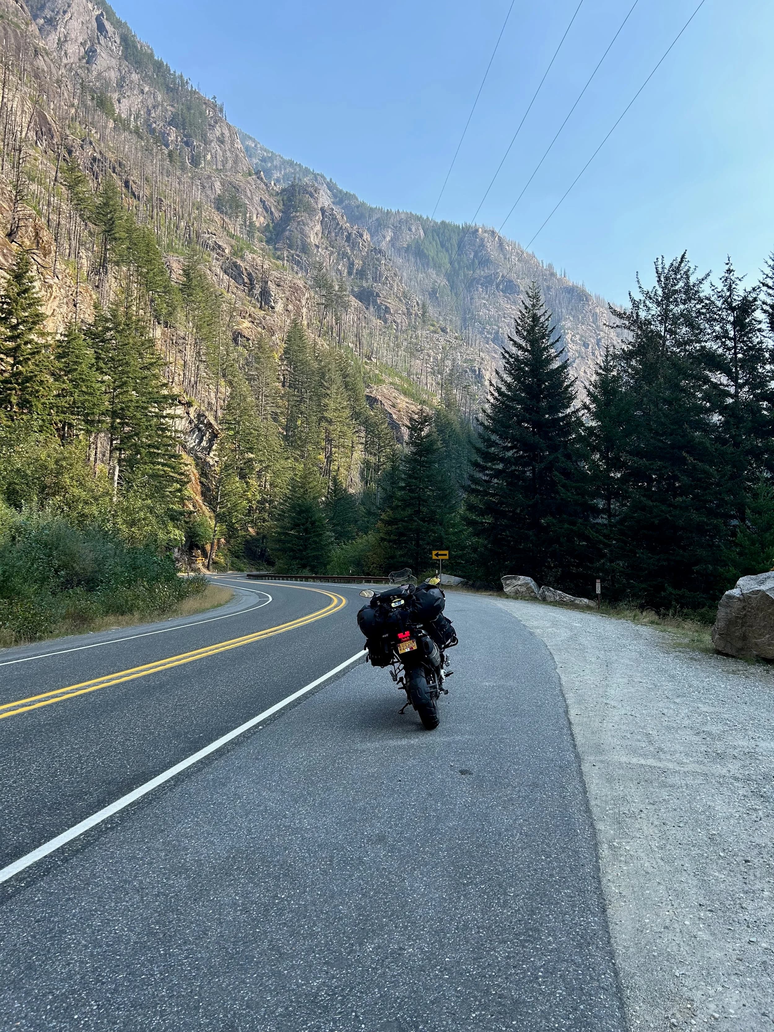 Trip Report: NW National Parks Loop
I left my job recently to take a much needed sabbatical and figure out what I’m doing next. A few weeks after my last day at work I embarked on what was to be a three week tour of NW-ish National Parks from Portland, to include Olympic, North Cascades, Glacier, Yellowstone, Grand Teton, Craters of the Moon, Lassen Volcanic, and Crater Lake.
I ended up missing Grand Tetons due to weather and I had to cut the trip short before I got to Lassen (family medical issue), so Lassen and Crater Lake remain unvisited.
Trip Dates: Sept 3 - Sept 16 (13 days)
Total Travel Miles: 3478 (does not include local miles for store runs, etc.)
Total Gallons of Gas Used: 82
Equipment: 2021 Benelli TRK502X Gaia GPS & Google Maps running on Sonim XP8 rugged Android phoneButler Motorcycle Maps (paper maps of best M/C roads in the country) iPhone 14 (main camera) Akaso Brave 7 helmet-mounted adventure camera Spot X satellite communicator and tracker Wolfman Luggage WP waterproof tank bag and saddle bags (no longer available) Watershed Colorado dry bag duffel (across the pillion seat) Kriega US-5 Drypack (tail bag) Kriega 3L hydration backpack (strapped to duffel, not worn)Marmot Ajax 2 tent Nemo hydrophobic down sleeping bag (non-mummy)Helinox ultralight cot MSR WhisperLite International stove
(Purchased in 1991 for my first moto trip: Detroit, MI to San Diego and back on an XT250)Gossamer Gear Bare Boxer bear-proof food canisters (two - one in each saddle bag)
Day 1 - Olympic National Park Date: Tuesday 9/3/2024
Destination: South Beach Campground, Olympic National Park
Travel Time: 4h 24m
Miles: 213Notes:
Planned to head west to Astoria then north from there, but left later than expected so headed up I-5 to US 12. I’ve driven/ridden that stretch of I-5 hundreds of times (starting in 1993). It’s boring and I hate it.
South Beach CG is first-come-first-served. I didn’t have issue getting a site. There is a long, tight loop of sites along the coastline, but I chose one of the sites further back near the bathrooms due to wind concerns. The bathroom building provided a sort of wind shelter for my site.
I used the heated grips on this leg; it was pretty chilly along the coast in the Olympic Peninsula. I almost didn’t install them, thinking I was being paranoid about the cold. I ended up using them a lot.
Day 2 - Ferry to Seattle / Burien Date: Wednesday 9/4/2024
Destination: Friend’s house in Burien, WA
Travel Time: 7h 30m
Miles: 199
Notes:
Slept well (thanks to Advil PM). I’ve not been sleeping well for more than a year. I’m really hoping to reset my sleep patterns with this trip. A good night’s sleep is one of my great joys and I feel like I’ve been robbed of that pleasure.
Used my Aeropress this morning for the first time ever. I’m hooked.
Headed up along US 101 through Port Angeles and then down to the Southworth ferry terminal near Port Orchard. Ferried across to Fauntleroy, which is just a few miles north my friend’s house in Burien. I’m always surprised at how long it takes to get from the Olympic Peninsula to the east side of Puget Sound (Seattle, etc.). With the ferry crossing (I love ferries) it took seven and a half hours to go 200 miles.
Discovered at my first stop of the day (just up 101 at the Kalaloch Campground, stopped to refill water) that the battery is quite weak and won’t start the bike if you leave the ignition on for even two minutes without the motor running. This would become a theme for the next few days. Fortunately, I have a jumper box and a permanent jump harness wired to the battery so jump starts are a quick operation.
Had a good evening with old friends.
Day 3 - North Cascades via Mountain Loop RoadDate: Thursday 9/5/2024
Destination: Newhalem Campground, North Cascades National Park
Travel Time: 4h 30m
Miles: 146Notes:
Slept well, on the couch. No pills needed.
I realized yesterday that my summer riding gloves (Rev’It Dune) were a size (or two) too small. Rev’It gloves fit really tight and I feel like I can never get it quite right. And yet, I love them. So, I stopped at a Cycle Gear in Bellevue to pick up something summer weight (Dirt 3) that fit better. They’re better, but maybe still one size too small. Such is life.
From Bellevue, I rode north and took the Mountain Loop Hwy then on up north to North Cascades. It was a hot ride. Still summer.
A small section of the Mountain Loop Road is dirt/gravel, which I didn’t realize. No biggie. Was just surprised (clearly I didn’t study my maps closely enough). When riding solo on a bike that weighs over 500 lbs., I tend to avoid planning much off-pavement riding. That’s what my DR-Z is for.
Day 4 - Newport, Washington via Winthrop Date: Friday 9/6/2024
Destination: Golden Spur Motor Inn, Newport, Washington
Travel Time: 8h
Miles: 308
Notes:
Slept just ok, even with Advil PM.
Pretty ride through North Cascades National Park and Colville National Forest. Didn’t do any backroads or hikes. Discovered (new to me) the town of Winthrop. Stopped for coffee at Sheri’s and resupplied on freeze-dried food at Cascades Outdoor Store.
The town of Newport is almost nothing, but, inexplicably, there’s an amazing restaurant (Brownell’s Place). Had dinner and a few ciders. Met and chatted with the owner/chef (she’s great). Listened to some live music. Then back to the motel.
Day 5 - New Battery in Kalispell Date: Saturday 9/7/2024
Destination: West Glacier KOA, West Glacier, MT
Travel Time: 8h 7m
Miles: 293
Notes:
Slept well on motel bed (on sleeping bag, not in the sheets). Another hot one.
Discovered that the water pump seal leaks oil. A quick post in the TRK Facebook group revealed that this is a common problem on this bike, and and easy fix. It’s apparently just a bad o-ring.
Battery has been getting continuously worse, and now requires I jump start the bike about every other start. Google Maps to the rescue: directions to the Batteries Plus in Kalispell, please. They don’t have an Odyssey AGM in the right size; the Duracell will have to do. (It’s been great.)
I set up camp at the West Glacier KOA, which will be my base for a few days. KOAs are their own little world. Very strange. Not really my thing, but the on-site laundry was handy.
After setting up camp I opened a cider and used the iPad to book a vehicle reservation for the next day to ride Going to the Sun Road, which I really wanted to do.
Day 6 - Going to the Sun RoadDate: Sunday 9/8/2024
Destination: Local Ride: West Glacier, Going to the Sun Road, Saint Mary, East Glacier
Travel Time: 5h 35m
Miles: 142Notes:
Quick breakfast and gas up in West Glacier before entering Going to the Sun Road.
Going to the Sun Road was stunning. This was the first point in the trip where I had tingles and was giddy at what I was seeing.
Took a very short hike along Saint Mary Lake. Again, I was beside myself with the beauty.
Lunch at the general store in Kiowa.
The rest of the ride back after East Glacier was meh, but I just kept thinking about how amazing what I’d seen in the morning had been.
Dinner at the KOA. Tacos from a cart (ok / not great, and a very weird guacamole) and a few glasses of wine from another cart. I asked about the guac and it turns out they make it in a food processor. Come on, people.
Day 7 - Ride to BozemanDate: Monday 9/9/2024
Destination: Friend’s house in Bozeman, Montana
Travel Time: ~ 8h (Gaia crashed near the end of the trip, but before getting to Bozeman)
Miles: ~ 400Notes:
Slept poorly again. No pills this time. Took some photos of my soft luggage setup to answer some questions in the TRK502X Facebook group. The saddle bags are from Wolfman Luggage, but I don’t think they make this waterproof line anymore. I use a duffel dry bag from Watershed across the top. A heat shield protects the side bag from exhaust heat.
Hazy, smoky ride most of the way. Very windy in places. This is where I first really started to feel how underpowered the TRK502 is. Really struggled in places.
Developed an engine-speed-sensitive squeak or rattle. Sounds like when a heat shield vibrates in resonance with engine vibration. Discovered that it’s a missing crash bar mounting bolt allowing the crash bar to rub against the frame.
Also noticed that there’s a resonant oscillation at speed that feels like the chain going bad (like it’s stretching unevenly).
First of several nights at a friend’s house in Bozeman (which, it turns out, is a pretty cool town). And there’s a hot tub…
Day 8 - Bike Maintenance & Hyalite ReservoirDate: Tuesday 9/10/2024
Destination: Local Ride: Hyalite Reservoir
Travel Time: not recorded
Miles: not recordedNotes:
Woke up to a smoky sunrise. I had the best night’s sleep I’ve had in years. This is was the whole point of this trip: to untangle my burnout and reclaim sleep as one of my joys. I wrote about it in my journal when I woke up. I hope this wasn’t a fluke.
Planned to replace the bolt that rattled loose from the crash bar, but instead discovered that it had actually severed off at the mount point. No fixing that on the road. Adjusted chain and moved on.
Lunch at Mountains Walking Brewery in Bozeman.
Rode up to Hyalite Reservoir. Pretty ride. Smoky still.
Soaked in hot tub after dinner.
Day 9 - North Yellowstone LoopDate: Wednesday 9/11/2024
Destination: Northern loop through Yellowstone National Park
Travel Time: 9h 36m
Miles: 272Notes:
Did a day trip from Bozeman down through the northern loop in Yellowstone, entering at Mammoth and taking the scenic route through Paradise Valley.
Saw elk, coyotes (I think), buffalo, and pronghorn.
Pretty ride, but cold in places. Used heated grips again.
Rode the loop through Mammoth Hot Springs (see video) at the end.
Coffee at Tumbleweed Bookstore & Cafe in Gardiner. I kind of dig Gardiner. Good vibe.
Had dinner at Mountains Walking Brewing. Rain and wind started. Lights flickered. Waited for rain to stop before riding back to the house.
Power out at the house due to high winds. This does not bode well for tomorrow.
Day 10 - Winter Weather in the ParksDate: Thursday 9/12/2024
Destination: Grand Teton National Park via West Yellowstone Pocatello, Idaho
Travel Time: 5h 40m
Miles: 201Notes:
Today was supposed to be a gorgeous ride through Yellowstone into Grand Teton National Park, and camping at Signal Mountain CG in the park. The weather had other ideas. It was pouring rain (and cold) all the way to West Yellowstone from Bozeman. By the time I got to West Yellowstone I was getting severe winter weather warnings on my phone calling for up to 3 (three!!) inches of snow accumulating in the high passes in the park. It’s bad enough in a car, but that’s a disaster waiting to happen on a motorcycle.
I parked my butt at Mountain Mama’s Cafe in West Yellowstone to warm up / dry off and decide what to do. I almost had myself convinced to push through when I realized that, even if I made it to the campground ok, I’d be setting up camp in the rain and I’d likely be miserable all night. Grand Teton would have to wait.
From West Yellowstone it’s easy to bail west into Idaho and get away from the park weather and elevations. So that’s what I did. It was not a pleasant ride, though. I was in torrential downpours all the way to Idaho Falls.
Arriving in Idaho Falls, I was exhausted and sure I could just find a room for the night. I dropped the bike at a roundabout (short-legged it coming to a stop; I knew it was going so I just rolled away). Guy behind me helped me pick it up. Then, there were no rooms because it was move in week for the two universities there (U of I, ISU). This would become a recurring theme.
I rode further to Blackfoot. Still no rooms.
I called ahead to Pocatello and got a room at a Red Lion there. I was never so happy to be off the bike.
No pictures this day. I couldn’t even get the action camera to turn on.
Day 11 - Craters of the Moon and EBR-1Date: Friday 9/13/2024
Destination: Craters of the Moon National Monument
Travel Time: 4h 20m
Miles: 124
Notes:
I wasn’t sure what my destination would be today but my plan was to do a little nuclear tourism, see Craters of the Moon, and then go somewhere from there. My schedule and day-plan was thrown off by missing Grand Teton National Park and spending a night in Pocatello, which was not on the itinerary at all.
Stopped in Atomic City. Not sure why; I was under the impression that Atomic City was the first city lit by nuclear engergy, but it was practically a ghost town. There are a few houses there, but as far as I could tell all of the business were shuttered. Except, maybe, for the race track; that looked like it might still get used.
Arco, it turns out, is the city celebrated as the first in the world to be lit by nuclear energy. Nothing special about the town, but they do a nice job of making City Hall photo-worthy.
Between Atomic City and Arco is EBR-1 (Experimental Breeder Reactor I) which was the world’s first breeder reactor. The EBR-1 exhibit was closed for the season, but in the lot next to it were some really interesting experimental nuclear heat-transfer jet engines that never made it out of the experimental phase (probably a good thing).
Craters of the Moon is pretty small. If you don’t do any of the walks, it’s literally just a 30 minute road loop. Still, it was an unexpected surprise and delight. I had no idea what to expect but I was positively chuffed at the experience. I noticed that the campground had open sites so I inquired at the entry booth. As luck would have it, the whole campground is first come / first serve. I decided to set up for the night. It’s good to be done early and have some time to read and not stress about making distance.
Day 12 - New Chain in Twin FallsDate: Saturday 9/14/2024
Destination: Battle Mountain, Nevada
Travel Time: 8h 52m
Miles: 335
Notes:
Beautiful morning in Craters of the Moon. While I was breaking camp a parade of classic cars came into the park to drive the loop. I got a picture of one Pontiac down the road in Carey at a gas station.
Carey ended up being an unplanned fork in the road for me. I discovered this morning that my chain was indeed stretching unevenly, and the oscillation I was feeling and hearing was the chain hum changing from a “loose” hum to a “tight” hum rapidly as the tight spot moved around the sprockets. I was supposed to continue west to Mountain Home and then south from there into Nevada. A very scenic route, according to my Butler map. But, between camp and the gas station I got pretty paranoid about the chain snapping at high speed, which, worst case, could lead to a fatal crash.
So I called ahead to a few motorcycle dealers in Mountain Home (on my planned route) to see if they could take me in and replace the chain. No dice. This is the downside of having an obscure motorcycle from an obscure marque - no one wants to work on it. Making matters worse this is an Italian-designed bike built in China, a fact which causes many people to lose the ability to think clearly. “It’s Chinese junk!” Not so. Next.
With Mountain Home out, I tried Twin Falls. My first call was to Adventure Motorsports, and the service manager there took me in with no hesitation. “How soon can you be here?” I didn’t get his name, but my hat’s off to him and his one tech working furiously on a Saturday to beat the 3pm closing time. He said during high season, they get about 15-20 out of town travelers per week who need something done, and they take them all in. I love to hear stuff like this. This shop is in it for the community. They have a nice showroom, too.
With a quality new chain installed, I got a burrito and a MexiCoke at a Mexican place and went on my way. I made it to Battle Mountain, NV, where I decide to get a room. Tomorrow I rejoin my planned scenic route. Day 13 - Desert Mountains in NV, CADate: Sunday 9/15/2024
Destination: Grizzly Campground, Lake Davis (near Portola, CA)
Travel Time: 7h
Miles: 307
Notes:
I love the northern Nevada landscape, and today’s ride didn’t disappoint. US Highway 50 is apparently known as “The Loneliest Highway” but everyone knows about it, so it’s not very lonely. However, after leaving Austin, NV headed west you can take Nevada Highway 722, which dips to the south and follows the old US 50 route. It was completely empty and the twisties through the passes were fun. Highly recommended.
Stopped in Fallon for gas and to find a Micro SD card for the action camera. Walmart to the rescue.
After Reno, I crossed into California and, I swear, it looks different. Norther California desert mountains are so beautiful.
Camped at a nearly empty campground on Lake Davis (very end of the season). The host warned me rain was coming tomorrow.
Day 14 - Unplanned Return HomeDate: Monday 9/16/2024
Destination: Summit Lake Campground, Lassen Volcanic National Park Portland, Oregon (Home)
Travel Time: 10h 32m
Miles: 538Notes:
Last week, my mom went into the hospital for a fairly routine procedure. My brother went to Michigan to help out, as needed, and he went back home to Arizona after she returned home and everything seemed settled.
This morning, while having coffee, I got a call that she’d gone back into the hospital with something that may or may not have been related to the procedure. It seemed like maybe things were ok, but maybe not.
I decided the best thing to do was head home so that I was near an airport if I needed to fly out to Michigan to help out.
I packed up camp and headed up US 395 toward home, via Klamath Falls. It was a pretty ride, but, once again, I found myself in rain most of the way to Klamath Falls.
I was pretty beat by the time I got to Klamath Falls and figured I’d just find a hotel room, get a hot shower, and finish the ride tomorrow.
But, once again, it was move-in week for the local university. Holiday Inn Express had a single room for $395. No thanks. Onward.
I never hit rain again after Klamath Falls, and after turning west onto Oregon Hwy 58 and starting to lose elevation into the Willamette Valley, the temperature starting rising, which was welcome.
Once I reached Eugene, there was no point in not just going all the way home, so that’s what I did.
I got two pictures: one at camp before the call, and one at my last gas stop, an hour and twenty minutes from home, with the moon rising.
A nice side effect of my early return home is that I was home for my birthday (tomorrow), so I had dinner with my kids and my wife, which was lovely.
I did end up flying to Michigan the next day, and was there for a bit. The best part? I got to make some meals for my mom and step dad. Everything seems ok with my mom for now.
Grand Teton, Lassen, and Crater Lake will be there, and now I have an excuse for another trip in the future.