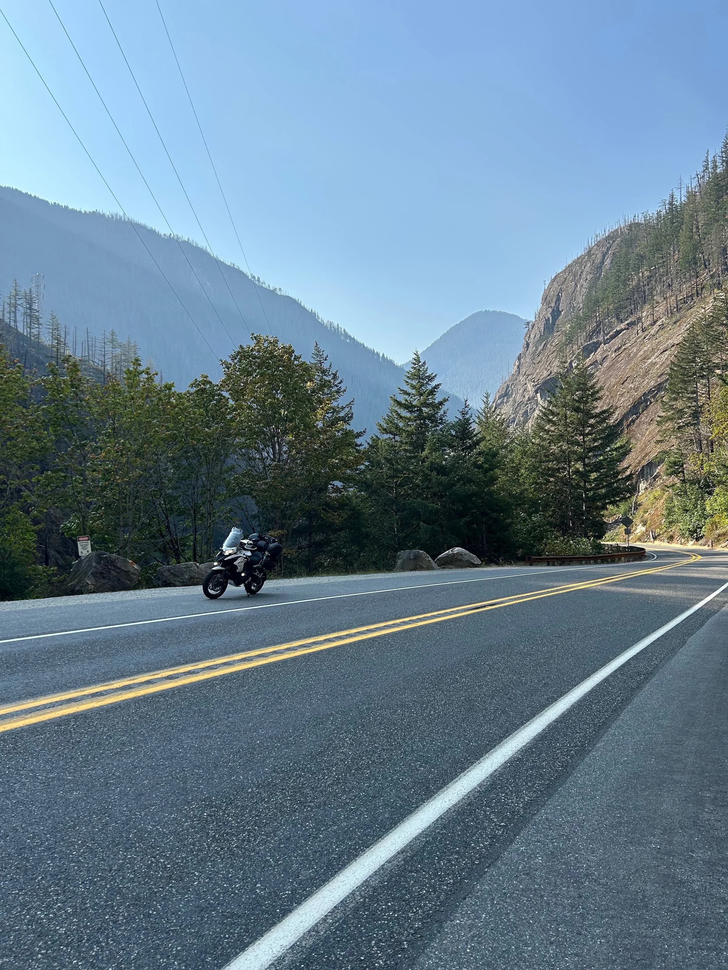 Trip Report: NW National Parks Loop
I left my job recently to take a much needed sabbatical and figure out what I’m doing next. A few weeks after my last day at work I embarked on what was to be a three week tour of NW-ish National Parks from Portland, to include Olympic, North Cascades, Glacier, Yellowstone, Grand Teton, Craters of the Moon, Lassen Volcanic, and Crater Lake.
I ended up missing Grand Tetons due to weather and I had to cut the trip short before I got to Lassen (family medical issue), so Lassen and Crater Lake remain unvisited.
Trip Dates: Sept 3 - Sept 16 (13 days)
Total Travel Miles: 3478 (does not include local miles for store runs, etc.)
Total Gallons of Gas Used: 82
Equipment: 2021 Benelli TRK502X Gaia GPS & Google Maps running on Sonim XP8 rugged Android phoneButler Motorcycle Maps (paper maps of best M/C roads in the country) iPhone 14 (main camera) Akaso Brave 7 helmet-mounted adventure camera Spot X satellite communicator and tracker Wolfman Luggage WP waterproof tank bag and saddle bags (no longer available) Watershed Colorado dry bag duffel (across the pillion seat) Kriega US-5 Drypack (tail bag) Kriega 3L hydration backpack (strapped to duffel, not worn)Marmot Ajax 2 tent Nemo hydrophobic down sleeping bag (non-mummy)Helinox ultralight cot MSR WhisperLite International stove
(Purchased in 1991 for my first moto trip: Detroit, MI to San Diego and back on an XT250)Gossamer Gear Bare Boxer bear-proof food canisters (two - one in each saddle bag)
Day 1 - Olympic National Park Date: Tuesday 9/3/2024
Destination: South Beach Campground, Olympic National Park
Travel Time: 4h 24m
Miles: 213Notes:
Planned to head west to Astoria then north from there, but left later than expected so headed up I-5 to US 12. I’ve driven/ridden that stretch of I-5 hundreds of times (starting in 1993). It’s boring and I hate it.
South Beach CG is first-come-first-served. I didn’t have issue getting a site. There is a long, tight loop of sites along the coastline, but I chose one of the sites further back near the bathrooms due to wind concerns. The bathroom building provided a sort of wind shelter for my site.
I used the heated grips on this leg; it was pretty chilly along the coast in the Olympic Peninsula. I almost didn’t install them, thinking I was being paranoid about the cold. I ended up using them a lot.
Day 2 - Ferry to Seattle / Burien Date: Wednesday 9/4/2024
Destination: Friend’s house in Burien, WA
Travel Time: 7h 30m
Miles: 199
Notes:
Slept well (thanks to Advil PM). I’ve not been sleeping well for more than a year. I’m really hoping to reset my sleep patterns with this trip. A good night’s sleep is one of my great joys and I feel like I’ve been robbed of that pleasure.
Used my Aeropress this morning for the first time ever. I’m hooked.
Headed up along US 101 through Port Angeles and then down to the Southworth ferry terminal near Port Orchard. Ferried across to Fauntleroy, which is just a few miles north my friend’s house in Burien. I’m always surprised at how long it takes to get from the Olympic Peninsula to the east side of Puget Sound (Seattle, etc.). With the ferry crossing (I love ferries) it took seven and a half hours to go 200 miles.
Discovered at my first stop of the day (just up 101 at the Kalaloch Campground, stopped to refill water) that the battery is quite weak and won’t start the bike if you leave the ignition on for even two minutes without the motor running. This would become a theme for the next few days. Fortunately, I have a jumper box and a permanent jump harness wired to the battery so jump starts are a quick operation.
Had a good evening with old friends.
Day 3 - North Cascades via Mountain Loop RoadDate: Thursday 9/5/2024
Destination: Newhalem Campground, North Cascades National Park
Travel Time: 4h 30m
Miles: 146Notes:
Slept well, on the couch. No pills needed.
I realized yesterday that my summer riding gloves (Rev’It Dune) were a size (or two) too small. Rev’It gloves fit really tight and I feel like I can never get it quite right. And yet, I love them. So, I stopped at a Cycle Gear in Bellevue to pick up something summer weight (Dirt 3) that fit better. They’re better, but maybe still one size too small. Such is life.
From Bellevue, I rode north and took the Mountain Loop Hwy then on up north to North Cascades. It was a hot ride. Still summer.
A small section of the Mountain Loop Road is dirt/gravel, which I didn’t realize. No biggie. Was just surprised (clearly I didn’t study my maps closely enough). When riding solo on a bike that weighs over 500 lbs., I tend to avoid planning much off-pavement riding. That’s what my DR-Z is for.
Day 4 - Newport, Washington via Winthrop Date: Friday 9/6/2024
Destination: Golden Spur Motor Inn, Newport, Washington
Travel Time: 8h
Miles: 308
Notes:
Slept just ok, even with Advil PM.
Pretty ride through North Cascades National Park and Colville National Forest. Didn’t do any backroads or hikes. Discovered (new to me) the town of Winthrop. Stopped for coffee at Sheri’s and resupplied on freeze-dried food at Cascades Outdoor Store.
The town of Newport is almost nothing, but, inexplicably, there’s an amazing restaurant (Brownell’s Place). Had dinner and a few ciders. Met and chatted with the owner/chef (she’s great). Listened to some live music. Then back to the motel.
Day 5 - New Battery in Kalispell Date: Saturday 9/7/2024
Destination: West Glacier KOA, West Glacier, MT
Travel Time: 8h 7m
Miles: 293
Notes:
Slept well on motel bed (on sleeping bag, not in the sheets). Another hot one.
Discovered that the water pump seal leaks oil. A quick post in the TRK Facebook group revealed that this is a common problem on this bike, and and easy fix. It’s apparently just a bad o-ring.
Battery has been getting continuously worse, and now requires I jump start the bike about every other start. Google Maps to the rescue: directions to the Batteries Plus in Kalispell, please. They don’t have an Odyssey AGM in the right size; the Duracell will have to do. (It’s been great.)
I set up camp at the West Glacier KOA, which will be my base for a few days. KOAs are their own little world. Very strange. Not really my thing, but the on-site laundry was handy.
After setting up camp I opened a cider and used the iPad to book a vehicle reservation for the next day to ride Going to the Sun Road, which I really wanted to do.
Day 6 - Going to the Sun RoadDate: Sunday 9/8/2024
Destination: Local Ride: West Glacier, Going to the Sun Road, Saint Mary, East Glacier
Travel Time: 5h 35m
Miles: 142Notes:
Quick breakfast and gas up in West Glacier before entering Going to the Sun Road.
Going to the Sun Road was stunning. This was the first point in the trip where I had tingles and was giddy at what I was seeing.
Took a very short hike along Saint Mary Lake. Again, I was beside myself with the beauty.
Lunch at the general store in Kiowa.
The rest of the ride back after East Glacier was meh, but I just kept thinking about how amazing what I’d seen in the morning had been.
Dinner at the KOA. Tacos from a cart (ok / not great, and a very weird guacamole) and a few glasses of wine from another cart. I asked about the guac and it turns out they make it in a food processor. Come on, people.
Day 7 - Ride to BozemanDate: Monday 9/9/2024
Destination: Friend’s house in Bozeman, Montana
Travel Time: ~ 8h (Gaia crashed near the end of the trip, but before getting to Bozeman)
Miles: ~ 400Notes:
Slept poorly again. No pills this time. Took some photos of my soft luggage setup to answer some questions in the TRK502X Facebook group. The saddle bags are from Wolfman Luggage, but I don’t think they make this waterproof line anymore. I use a duffel dry bag from Watershed across the top. A heat shield protects the side bag from exhaust heat.
Hazy, smoky ride most of the way. Very windy in places. This is where I first really started to feel how underpowered the TRK502 is. Really struggled in places.
Developed an engine-speed-sensitive squeak or rattle. Sounds like when a heat shield vibrates in resonance with engine vibration. Discovered that it’s a missing crash bar mounting bolt allowing the crash bar to rub against the frame.
Also noticed that there’s a resonant oscillation at speed that feels like the chain going bad (like it’s stretching unevenly).
First of several nights at a friend’s house in Bozeman (which, it turns out, is a pretty cool town). And there’s a hot tub…
Day 8 - Bike Maintenance & Hyalite ReservoirDate: Tuesday 9/10/2024
Destination: Local Ride: Hyalite Reservoir
Travel Time: not recorded
Miles: not recordedNotes:
Woke up to a smoky sunrise. I had the best night’s sleep I’ve had in years. This is was the whole point of this trip: to untangle my burnout and reclaim sleep as one of my joys. I wrote about it in my journal when I woke up. I hope this wasn’t a fluke.
Planned to replace the bolt that rattled loose from the crash bar, but instead discovered that it had actually severed off at the mount point. No fixing that on the road. Adjusted chain and moved on.
Lunch at Mountains Walking Brewery in Bozeman.
Rode up to Hyalite Reservoir. Pretty ride. Smoky still.
Soaked in hot tub after dinner.
Day 9 - North Yellowstone LoopDate: Wednesday 9/11/2024
Destination: Northern loop through Yellowstone National Park
Travel Time: 9h 36m
Miles: 272Notes:
Did a day trip from Bozeman down through the northern loop in Yellowstone, entering at Mammoth and taking the scenic route through Paradise Valley.
Saw elk, coyotes (I think), buffalo, and pronghorn.
Pretty ride, but cold in places. Used heated grips again.
Rode the loop through Mammoth Hot Springs (see video) at the end.
Coffee at Tumbleweed Bookstore & Cafe in Gardiner. I kind of dig Gardiner. Good vibe.
Had dinner at Mountains Walking Brewing. Rain and wind started. Lights flickered. Waited for rain to stop before riding back to the house.
Power out at the house due to high winds. This does not bode well for tomorrow.
Day 10 - Winter Weather in the ParksDate: Thursday 9/12/2024
Destination: Grand Teton National Park via West Yellowstone Pocatello, Idaho
Travel Time: 5h 40m
Miles: 201Notes:
Today was supposed to be a gorgeous ride through Yellowstone into Grand Teton National Park, and camping at Signal Mountain CG in the park. The weather had other ideas. It was pouring rain (and cold) all the way to West Yellowstone from Bozeman. By the time I got to West Yellowstone I was getting severe winter weather warnings on my phone calling for up to 3 (three!!) inches of snow accumulating in the high passes in the park. It’s bad enough in a car, but that’s a disaster waiting to happen on a motorcycle.
I parked my butt at Mountain Mama’s Cafe in West Yellowstone to warm up / dry off and decide what to do. I almost had myself convinced to push through when I realized that, even if I made it to the campground ok, I’d be setting up camp in the rain and I’d likely be miserable all night. Grand Teton would have to wait.
From West Yellowstone it’s easy to bail west into Idaho and get away from the park weather and elevations. So that’s what I did. It was not a pleasant ride, though. I was in torrential downpours all the way to Idaho Falls.
Arriving in Idaho Falls, I was exhausted and sure I could just find a room for the night. I dropped the bike at a roundabout (short-legged it coming to a stop; I knew it was going so I just rolled away). Guy behind me helped me pick it up. Then, there were no rooms because it was move in week for the two universities there (U of I, ISU). This would become a recurring theme.
I rode further to Blackfoot. Still no rooms.
I called ahead to Pocatello and got a room at a Red Lion there. I was never so happy to be off the bike.
No pictures this day. I couldn’t even get the action camera to turn on.
Day 11 - Craters of the Moon and EBR-1Date: Friday 9/13/2024
Destination: Craters of the Moon National Monument
Travel Time: 4h 20m
Miles: 124
Notes:
I wasn’t sure what my destination would be today but my plan was to do a little nuclear tourism, see Craters of the Moon, and then go somewhere from there. My schedule and day-plan was thrown off by missing Grand Teton National Park and spending a night in Pocatello, which was not on the itinerary at all.
Stopped in Atomic City. Not sure why; I was under the impression that Atomic City was the first city lit by nuclear engergy, but it was practically a ghost town. There are a few houses there, but as far as I could tell all of the business were shuttered. Except, maybe, for the race track; that looked like it might still get used.
Arco, it turns out, is the city celebrated as the first in the world to be lit by nuclear energy. Nothing special about the town, but they do a nice job of making City Hall photo-worthy.
Between Atomic City and Arco is EBR-1 (Experimental Breeder Reactor I) which was the world’s first breeder reactor. The EBR-1 exhibit was closed for the season, but in the lot next to it were some really interesting experimental nuclear heat-transfer jet engines that never made it out of the experimental phase (probably a good thing).
Craters of the Moon is pretty small. If you don’t do any of the walks, it’s literally just a 30 minute road loop. Still, it was an unexpected surprise and delight. I had no idea what to expect but I was positively chuffed at the experience. I noticed that the campground had open sites so I inquired at the entry booth. As luck would have it, the whole campground is first come / first serve. I decided to set up for the night. It’s good to be done early and have some time to read and not stress about making distance.
Day 12 - New Chain in Twin FallsDate: Saturday 9/14/2024
Destination: Battle Mountain, Nevada
Travel Time: 8h 52m
Miles: 335
Notes:
Beautiful morning in Craters of the Moon. While I was breaking camp a parade of classic cars came into the park to drive the loop. I got a picture of one Pontiac down the road in Carey at a gas station.
Carey ended up being an unplanned fork in the road for me. I discovered this morning that my chain was indeed stretching unevenly, and the oscillation I was feeling and hearing was the chain hum changing from a “loose” hum to a “tight” hum rapidly as the tight spot moved around the sprockets. I was supposed to continue west to Mountain Home and then south from there into Nevada. A very scenic route, according to my Butler map. But, between camp and the gas station I got pretty paranoid about the chain snapping at high speed, which, worst case, could lead to a fatal crash.
So I called ahead to a few motorcycle dealers in Mountain Home (on my planned route) to see if they could take me in and replace the chain. No dice. This is the downside of having an obscure motorcycle from an obscure marque - no one wants to work on it. Making matters worse this is an Italian-designed bike built in China, a fact which causes many people to lose the ability to think clearly. “It’s Chinese junk!” Not so. Next.
With Mountain Home out, I tried Twin Falls. My first call was to Adventure Motorsports, and the service manager there took me in with no hesitation. “How soon can you be here?” I didn’t get his name, but my hat’s off to him and his one tech working furiously on a Saturday to beat the 3pm closing time. He said during high season, they get about 15-20 out of town travelers per week who need something done, and they take them all in. I love to hear stuff like this. This shop is in it for the community. They have a nice showroom, too.
With a quality new chain installed, I got a burrito and a MexiCoke at a Mexican place and went on my way. I made it to Battle Mountain, NV, where I decide to get a room. Tomorrow I rejoin my planned scenic route. Day 13 - Desert Mountains in NV, CADate: Sunday 9/15/2024
Destination: Grizzly Campground, Lake Davis (near Portola, CA)
Travel Time: 7h
Miles: 307
Notes:
I love the northern Nevada landscape, and today’s ride didn’t disappoint. US Highway 50 is apparently known as “The Loneliest Highway” but everyone knows about it, so it’s not very lonely. However, after leaving Austin, NV headed west you can take Nevada Highway 722, which dips to the south and follows the old US 50 route. It was completely empty and the twisties through the passes were fun. Highly recommended.
Stopped in Fallon for gas and to find a Micro SD card for the action camera. Walmart to the rescue.
After Reno, I crossed into California and, I swear, it looks different. Norther California desert mountains are so beautiful.
Camped at a nearly empty campground on Lake Davis (very end of the season). The host warned me rain was coming tomorrow.
Day 14 - Unplanned Return HomeDate: Monday 9/16/2024
Destination: Summit Lake Campground, Lassen Volcanic National Park Portland, Oregon (Home)
Travel Time: 10h 32m
Miles: 538Notes:
Last week, my mom went into the hospital for a fairly routine procedure. My brother went to Michigan to help out, as needed, and he went back home to Arizona after she returned home and everything seemed settled.
This morning, while having coffee, I got a call that she’d gone back into the hospital with something that may or may not have been related to the procedure. It seemed like maybe things were ok, but maybe not.
I decided the best thing to do was head home so that I was near an airport if I needed to fly out to Michigan to help out.
I packed up camp and headed up US 395 toward home, via Klamath Falls. It was a pretty ride, but, once again, I found myself in rain most of the way to Klamath Falls.
I was pretty beat by the time I got to Klamath Falls and figured I’d just find a hotel room, get a hot shower, and finish the ride tomorrow.
But, once again, it was move-in week for the local university. Holiday Inn Express had a single room for $395. No thanks. Onward.
I never hit rain again after Klamath Falls, and after turning west onto Oregon Hwy 58 and starting to lose elevation into the Willamette Valley, the temperature starting rising, which was welcome.
Once I reached Eugene, there was no point in not just going all the way home, so that’s what I did.
I got two pictures: one at camp before the call, and one at my last gas stop, an hour and twenty minutes from home, with the moon rising.
A nice side effect of my early return home is that I was home for my birthday (tomorrow), so I had dinner with my kids and my wife, which was lovely.
I did end up flying to Michigan the next day, and was there for a bit. The best part? I got to make some meals for my mom and step dad. Everything seems ok with my mom for now.
Grand Teton, Lassen, and Crater Lake will be there, and now I have an excuse for another trip in the future.