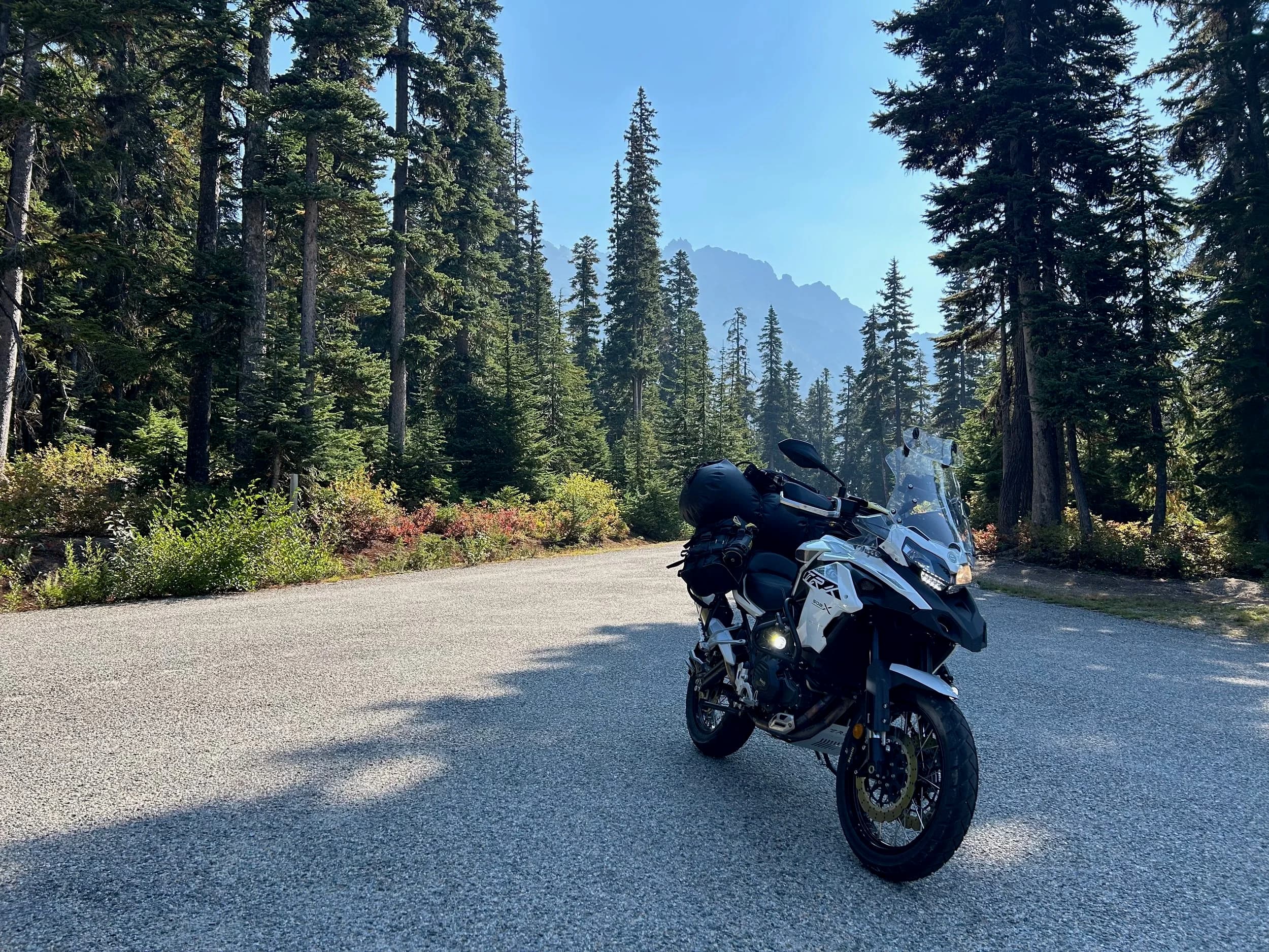 Trip Report: NW National Parks Loop
I left my job recently to take a much needed sabbatical and figure out what I’m doing next. A few weeks after my last day at work I embarked on what was to be a three week tour of NW-ish National Parks from Portland, to include Olympic, North Cascades, Glacier, Yellowstone, Grand Teton, Craters of the Moon, Lassen Volcanic, and Crater Lake.
I ended up missing Grand Tetons due to weather and I had to cut the trip short before I got to Lassen (family medical issue), so Lassen and Crater Lake remain unvisited.
Trip Dates: Sept 3 - Sept 16 (13 days)
Total Travel Miles: 3478 (does not include local miles for store runs, etc.)
Total Gallons of Gas Used: 82
Equipment: 2021 Benelli TRK502X Gaia GPS & Google Maps running on Sonim XP8 rugged Android phoneButler Motorcycle Maps (paper maps of best M/C roads in the country) iPhone 14 (main camera) Akaso Brave 7 helmet-mounted adventure camera Spot X satellite communicator and tracker Wolfman Luggage WP waterproof tank bag and saddle bags (no longer available) Watershed Colorado dry bag duffel (across the pillion seat) Kriega US-5 Drypack (tail bag) Kriega 3L hydration backpack (strapped to duffel, not worn)Marmot Ajax 2 tent Nemo hydrophobic down sleeping bag (non-mummy)Helinox ultralight cot MSR WhisperLite International stove
(Purchased in 1991 for my first moto trip: Detroit, MI to San Diego and back on an XT250)Gossamer Gear Bare Boxer bear-proof food canisters (two - one in each saddle bag)
Day 1 - Olympic National Park Date: Tuesday 9/3/2024
Destination: South Beach Campground, Olympic National Park
Travel Time: 4h 24m
Miles: 213Notes:
Planned to head west to Astoria then north from there, but left later than expected so headed up I-5 to US 12. I’ve driven/ridden that stretch of I-5 hundreds of times (starting in 1993). It’s boring and I hate it.
South Beach CG is first-come-first-served. I didn’t have issue getting a site. There is a long, tight loop of sites along the coastline, but I chose one of the sites further back near the bathrooms due to wind concerns. The bathroom building provided a sort of wind shelter for my site.
I used the heated grips on this leg; it was pretty chilly along the coast in the Olympic Peninsula. I almost didn’t install them, thinking I was being paranoid about the cold. I ended up using them a lot.
Day 2 - Ferry to Seattle / Burien Date: Wednesday 9/4/2024
Destination: Friend’s house in Burien, WA
Travel Time: 7h 30m
Miles: 199
Notes:
Slept well (thanks to Advil PM). I’ve not been sleeping well for more than a year. I’m really hoping to reset my sleep patterns with this trip. A good night’s sleep is one of my great joys and I feel like I’ve been robbed of that pleasure.
Used my Aeropress this morning for the first time ever. I’m hooked.
Headed up along US 101 through Port Angeles and then down to the Southworth ferry terminal near Port Orchard. Ferried across to Fauntleroy, which is just a few miles north my friend’s house in Burien. I’m always surprised at how long it takes to get from the Olympic Peninsula to the east side of Puget Sound (Seattle, etc.). With the ferry crossing (I love ferries) it took seven and a half hours to go 200 miles.
Discovered at my first stop of the day (just up 101 at the Kalaloch Campground, stopped to refill water) that the battery is quite weak and won’t start the bike if you leave the ignition on for even two minutes without the motor running. This would become a theme for the next few days. Fortunately, I have a jumper box and a permanent jump harness wired to the battery so jump starts are a quick operation.
Had a good evening with old friends.
Day 3 - North Cascades via Mountain Loop RoadDate: Thursday 9/5/2024
Destination: Newhalem Campground, North Cascades National Park
Travel Time: 4h 30m
Miles: 146Notes:
Slept well, on the couch. No pills needed.
I realized yesterday that my summer riding gloves (Rev’It Dune) were a size (or two) too small. Rev’It gloves fit really tight and I feel like I can never get it quite right. And yet, I love them. So, I stopped at a Cycle Gear in Bellevue to pick up something summer weight (Dirt 3) that fit better. They’re better, but maybe still one size too small. Such is life.
From Bellevue, I rode north and took the Mountain Loop Hwy then on up north to North Cascades. It was a hot ride. Still summer.
A small section of the Mountain Loop Road is dirt/gravel, which I didn’t realize. No biggie. Was just surprised (clearly I didn’t study my maps closely enough). When riding solo on a bike that weighs over 500 lbs., I tend to avoid planning much off-pavement riding. That’s what my DR-Z is for.
Day 4 - Newport, Washington via Winthrop Date: Friday 9/6/2024
Destination: Golden Spur Motor Inn, Newport, Washington
Travel Time: 8h
Miles: 308
Notes:
Slept just ok, even with Advil PM.
Pretty ride through North Cascades National Park and Colville National Forest. Didn’t do any backroads or hikes. Discovered (new to me) the town of Winthrop. Stopped for coffee at Sheri’s and resupplied on freeze-dried food at Cascades Outdoor Store.
The town of Newport is almost nothing, but, inexplicably, there’s an amazing restaurant (Brownell’s Place). Had dinner and a few ciders. Met and chatted with the owner/chef (she’s great). Listened to some live music. Then back to the motel.
Day 5 - New Battery in Kalispell Date: Saturday 9/7/2024
Destination: West Glacier KOA, West Glacier, MT
Travel Time: 8h 7m
Miles: 293
Notes:
Slept well on motel bed (on sleeping bag, not in the sheets). Another hot one.
Discovered that the water pump seal leaks oil. A quick post in the TRK Facebook group revealed that this is a common problem on this bike, and and easy fix. It’s apparently just a bad o-ring.
Battery has been getting continuously worse, and now requires I jump start the bike about every other start. Google Maps to the rescue: directions to the Batteries Plus in Kalispell, please. They don’t have an Odyssey AGM in the right size; the Duracell will have to do. (It’s been great.)
I set up camp at the West Glacier KOA, which will be my base for a few days. KOAs are their own little world. Very strange. Not really my thing, but the on-site laundry was handy.
After setting up camp I opened a cider and used the iPad to book a vehicle reservation for the next day to ride Going to the Sun Road, which I really wanted to do.
Day 6 - Going to the Sun RoadDate: Sunday 9/8/2024
Destination: Local Ride: West Glacier, Going to the Sun Road, Saint Mary, East Glacier
Travel Time: 5h 35m
Miles: 142Notes:
Quick breakfast and gas up in West Glacier before entering Going to the Sun Road.
Going to the Sun Road was stunning. This was the first point in the trip where I had tingles and was giddy at what I was seeing.
Took a very short hike along Saint Mary Lake. Again, I was beside myself with the beauty.
Lunch at the general store in Kiowa.
The rest of the ride back after East Glacier was meh, but I just kept thinking about how amazing what I’d seen in the morning had been.
Dinner at the KOA. Tacos from a cart (ok / not great, and a very weird guacamole) and a few glasses of wine from another cart. I asked about the guac and it turns out they make it in a food processor. Come on, people.
Day 7 - Ride to BozemanDate: Monday 9/9/2024
Destination: Friend’s house in Bozeman, Montana
Travel Time: ~ 8h (Gaia crashed near the end of the trip, but before getting to Bozeman)
Miles: ~ 400Notes:
Slept poorly again. No pills this time. Took some photos of my soft luggage setup to answer some questions in the TRK502X Facebook group. The saddle bags are from Wolfman Luggage, but I don’t think they make this waterproof line anymore. I use a duffel dry bag from Watershed across the top. A heat shield protects the side bag from exhaust heat.
Hazy, smoky ride most of the way. Very windy in places. This is where I first really started to feel how underpowered the TRK502 is. Really struggled in places.
Developed an engine-speed-sensitive squeak or rattle. Sounds like when a heat shield vibrates in resonance with engine vibration. Discovered that it’s a missing crash bar mounting bolt allowing the crash bar to rub against the frame.
Also noticed that there’s a resonant oscillation at speed that feels like the chain going bad (like it’s stretching unevenly).
First of several nights at a friend’s house in Bozeman (which, it turns out, is a pretty cool town). And there’s a hot tub…
Day 8 - Bike Maintenance & Hyalite ReservoirDate: Tuesday 9/10/2024
Destination: Local Ride: Hyalite Reservoir
Travel Time: not recorded
Miles: not recordedNotes:
Woke up to a smoky sunrise. I had the best night’s sleep I’ve had in years. This is was the whole point of this trip: to untangle my burnout and reclaim sleep as one of my joys. I wrote about it in my journal when I woke up. I hope this wasn’t a fluke.
Planned to replace the bolt that rattled loose from the crash bar, but instead discovered that it had actually severed off at the mount point. No fixing that on the road. Adjusted chain and moved on.
Lunch at Mountains Walking Brewery in Bozeman.
Rode up to Hyalite Reservoir. Pretty ride. Smoky still.
Soaked in hot tub after dinner.
Day 9 - North Yellowstone LoopDate: Wednesday 9/11/2024
Destination: Northern loop through Yellowstone National Park
Travel Time: 9h 36m
Miles: 272Notes:
Did a day trip from Bozeman down through the northern loop in Yellowstone, entering at Mammoth and taking the scenic route through Paradise Valley.
Saw elk, coyotes (I think), buffalo, and pronghorn.
Pretty ride, but cold in places. Used heated grips again.
Rode the loop through Mammoth Hot Springs (see video) at the end.
Coffee at Tumbleweed Bookstore & Cafe in Gardiner. I kind of dig Gardiner. Good vibe.
Had dinner at Mountains Walking Brewing. Rain and wind started. Lights flickered. Waited for rain to stop before riding back to the house.
Power out at the house due to high winds. This does not bode well for tomorrow.
Day 10 - Winter Weather in the ParksDate: Thursday 9/12/2024
Destination: Grand Teton National Park via West Yellowstone Pocatello, Idaho
Travel Time: 5h 40m
Miles: 201Notes:
Today was supposed to be a gorgeous ride through Yellowstone into Grand Teton National Park, and camping at Signal Mountain CG in the park. The weather had other ideas. It was pouring rain (and cold) all the way to West Yellowstone from Bozeman. By the time I got to West Yellowstone I was getting severe winter weather warnings on my phone calling for up to 3 (three!!) inches of snow accumulating in the high passes in the park. It’s bad enough in a car, but that’s a disaster waiting to happen on a motorcycle.
I parked my butt at Mountain Mama’s Cafe in West Yellowstone to warm up / dry off and decide what to do. I almost had myself convinced to push through when I realized that, even if I made it to the campground ok, I’d be setting up camp in the rain and I’d likely be miserable all night. Grand Teton would have to wait.
From West Yellowstone it’s easy to bail west into Idaho and get away from the park weather and elevations. So that’s what I did. It was not a pleasant ride, though. I was in torrential downpours all the way to Idaho Falls.
Arriving in Idaho Falls, I was exhausted and sure I could just find a room for the night. I dropped the bike at a roundabout (short-legged it coming to a stop; I knew it was going so I just rolled away). Guy behind me helped me pick it up. Then, there were no rooms because it was move in week for the two universities there (U of I, ISU). This would become a recurring theme.
I rode further to Blackfoot. Still no rooms.
I called ahead to Pocatello and got a room at a Red Lion there. I was never so happy to be off the bike.
No pictures this day. I couldn’t even get the action camera to turn on.
Day 11 - Craters of the Moon and EBR-1Date: Friday 9/13/2024
Destination: Craters of the Moon National Monument
Travel Time: 4h 20m
Miles: 124
Notes:
I wasn’t sure what my destination would be today but my plan was to do a little nuclear tourism, see Craters of the Moon, and then go somewhere from there. My schedule and day-plan was thrown off by missing Grand Teton National Park and spending a night in Pocatello, which was not on the itinerary at all.
Stopped in Atomic City. Not sure why; I was under the impression that Atomic City was the first city lit by nuclear engergy, but it was practically a ghost town. There are a few houses there, but as far as I could tell all of the business were shuttered. Except, maybe, for the race track; that looked like it might still get used.
Arco, it turns out, is the city celebrated as the first in the world to be lit by nuclear energy. Nothing special about the town, but they do a nice job of making City Hall photo-worthy.
Between Atomic City and Arco is EBR-1 (Experimental Breeder Reactor I) which was the world’s first breeder reactor. The EBR-1 exhibit was closed for the season, but in the lot next to it were some really interesting experimental nuclear heat-transfer jet engines that never made it out of the experimental phase (probably a good thing).
Craters of the Moon is pretty small. If you don’t do any of the walks, it’s literally just a 30 minute road loop. Still, it was an unexpected surprise and delight. I had no idea what to expect but I was positively chuffed at the experience. I noticed that the campground had open sites so I inquired at the entry booth. As luck would have it, the whole campground is first come / first serve. I decided to set up for the night. It’s good to be done early and have some time to read and not stress about making distance.
Day 12 - New Chain in Twin FallsDate: Saturday 9/14/2024
Destination: Battle Mountain, Nevada
Travel Time: 8h 52m
Miles: 335
Notes:
Beautiful morning in Craters of the Moon. While I was breaking camp a parade of classic cars came into the park to drive the loop. I got a picture of one Pontiac down the road in Carey at a gas station.
Carey ended up being an unplanned fork in the road for me. I discovered this morning that my chain was indeed stretching unevenly, and the oscillation I was feeling and hearing was the chain hum changing from a “loose” hum to a “tight” hum rapidly as the tight spot moved around the sprockets. I was supposed to continue west to Mountain Home and then south from there into Nevada. A very scenic route, according to my Butler map. But, between camp and the gas station I got pretty paranoid about the chain snapping at high speed, which, worst case, could lead to a fatal crash.
So I called ahead to a few motorcycle dealers in Mountain Home (on my planned route) to see if they could take me in and replace the chain. No dice. This is the downside of having an obscure motorcycle from an obscure marque - no one wants to work on it. Making matters worse this is an Italian-designed bike built in China, a fact which causes many people to lose the ability to think clearly. “It’s Chinese junk!” Not so. Next.
With Mountain Home out, I tried Twin Falls. My first call was to Adventure Motorsports, and the service manager there took me in with no hesitation. “How soon can you be here?” I didn’t get his name, but my hat’s off to him and his one tech working furiously on a Saturday to beat the 3pm closing time. He said during high season, they get about 15-20 out of town travelers per week who need something done, and they take them all in. I love to hear stuff like this. This shop is in it for the community. They have a nice showroom, too.
With a quality new chain installed, I got a burrito and a MexiCoke at a Mexican place and went on my way. I made it to Battle Mountain, NV, where I decide to get a room. Tomorrow I rejoin my planned scenic route. Day 13 - Desert Mountains in NV, CADate: Sunday 9/15/2024
Destination: Grizzly Campground, Lake Davis (near Portola, CA)
Travel Time: 7h
Miles: 307
Notes:
I love the northern Nevada landscape, and today’s ride didn’t disappoint. US Highway 50 is apparently known as “The Loneliest Highway” but everyone knows about it, so it’s not very lonely. However, after leaving Austin, NV headed west you can take Nevada Highway 722, which dips to the south and follows the old US 50 route. It was completely empty and the twisties through the passes were fun. Highly recommended.
Stopped in Fallon for gas and to find a Micro SD card for the action camera. Walmart to the rescue.
After Reno, I crossed into California and, I swear, it looks different. Norther California desert mountains are so beautiful.
Camped at a nearly empty campground on Lake Davis (very end of the season). The host warned me rain was coming tomorrow.
Day 14 - Unplanned Return HomeDate: Monday 9/16/2024
Destination: Summit Lake Campground, Lassen Volcanic National Park Portland, Oregon (Home)
Travel Time: 10h 32m
Miles: 538Notes:
Last week, my mom went into the hospital for a fairly routine procedure. My brother went to Michigan to help out, as needed, and he went back home to Arizona after she returned home and everything seemed settled.
This morning, while having coffee, I got a call that she’d gone back into the hospital with something that may or may not have been related to the procedure. It seemed like maybe things were ok, but maybe not.
I decided the best thing to do was head home so that I was near an airport if I needed to fly out to Michigan to help out.
I packed up camp and headed up US 395 toward home, via Klamath Falls. It was a pretty ride, but, once again, I found myself in rain most of the way to Klamath Falls.
I was pretty beat by the time I got to Klamath Falls and figured I’d just find a hotel room, get a hot shower, and finish the ride tomorrow.
But, once again, it was move-in week for the local university. Holiday Inn Express had a single room for $395. No thanks. Onward.
I never hit rain again after Klamath Falls, and after turning west onto Oregon Hwy 58 and starting to lose elevation into the Willamette Valley, the temperature starting rising, which was welcome.
Once I reached Eugene, there was no point in not just going all the way home, so that’s what I did.
I got two pictures: one at camp before the call, and one at my last gas stop, an hour and twenty minutes from home, with the moon rising.
A nice side effect of my early return home is that I was home for my birthday (tomorrow), so I had dinner with my kids and my wife, which was lovely.
I did end up flying to Michigan the next day, and was there for a bit. The best part? I got to make some meals for my mom and step dad. Everything seems ok with my mom for now.
Grand Teton, Lassen, and Crater Lake will be there, and now I have an excuse for another trip in the future.