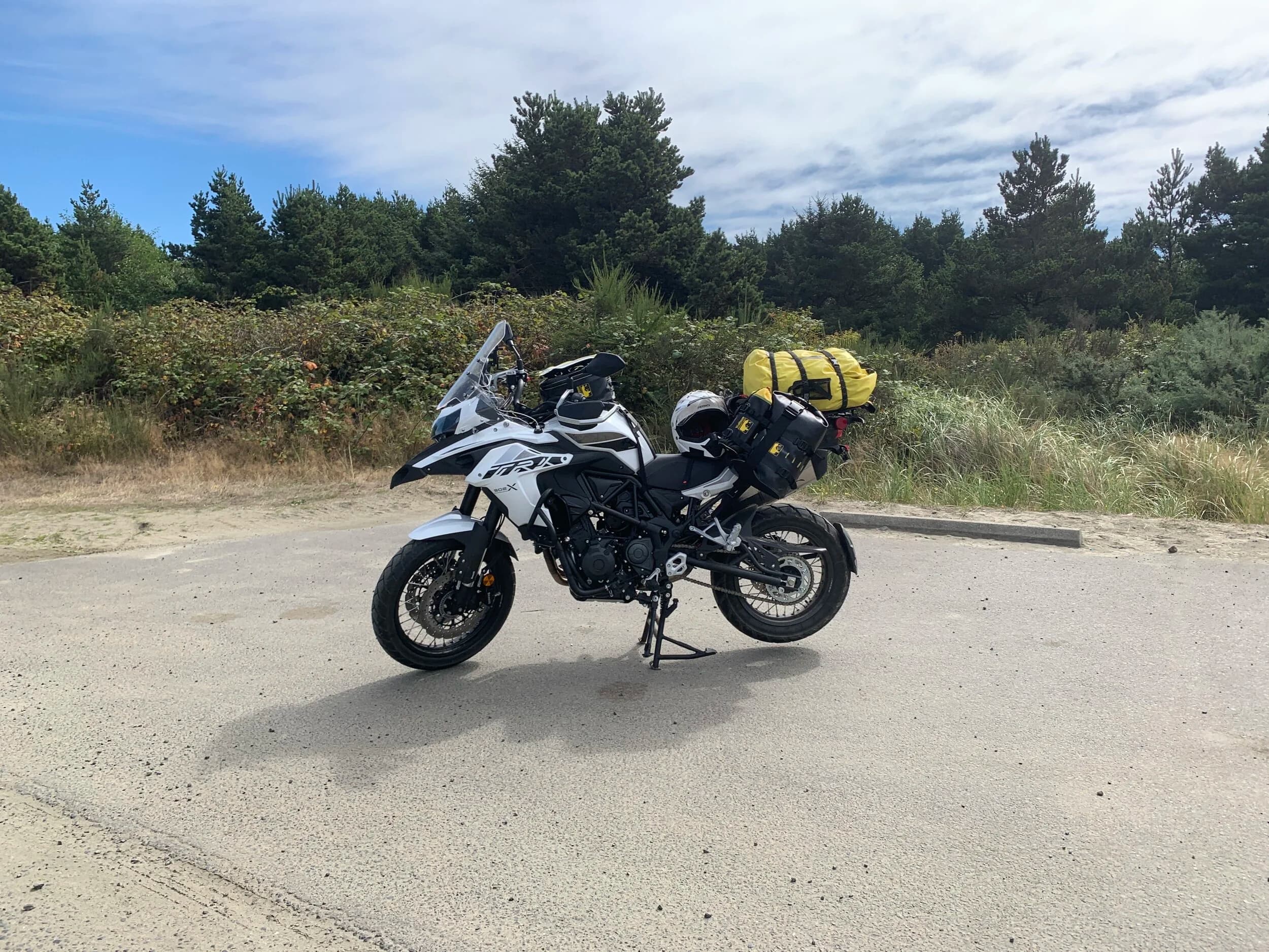 Trip Report: Portland to Olympic Peninsula to Orcas Island
If you follow me on Instagram, you know I purchased a 2021 Benelli TRK502X in July. I just completed my first overnight trip with the new Benelli, doing 7 nights / 8 days from Portland, up the Olympic Peninsula, over to Bellingham and then finally to Orcas Island.
The plan was to camp most or all nights until my last two nights on Orcas, where I had a small waterfront cottage rented right in Orcas Village, where the ferry lands. After three nights of camping, however, I realized I can’t really do the “thin air pad on the ground” thing anymore (I’d be 50 in a week, after all!). My back was killing me and I was not sleeping well, making the following day’s ride less enjoyable at best, and probably also less safe.
So, instead of 5 nights of camping, I did three and then found a cheap motel in Port Angeles, figuring I’d camp the next night and then do my two nights in the cottage. As it happened, most of the next day was rain and the forecast was rain all night and into the morning, so I ended up in a hotel in Bellingham to avoid setting up and breaking down camp in the rain. I can do it. Have done it. But if money is no object and there is lodging available, why be miserable?
The route I planned was intended to get me familiar with the TRK’s manners while allowing for the fact that I’d be riding solo and really didn’t want to get into trouble that I couldn’t get myself out of. The 502X, despite being a 500cc bike, is not light. Curb weight is listed as 518 lbs (dry is 470). So, I favored two lane highways, but included some backcountry single lane roads that were a mix of pavement and gravel.
Here’s my trip report. Day 1Planned / Actual Destination: Cape Disappointment State Park
Planned / Actual Accommodation: Camping
Planned / Actual Miles: 201 / 212
Planned Route: Tigard to Seaside via the Nestucca River Backcountry Byway; Seaside to Cape Disappointment via US 101.
Route NotesI let Google guide me to Carlton from Tigard (home base). On Gaia GPS, I had planned a route that followed the Nestucca River Backcountry Byway from Carlton to Beaver. Unfortunately, there was a detour after McGuire Reservoir (the body of water at the left edge of the right third of the map above) that took me well south down to Bell Mountain along Bald Mountain Rd before heading back north again and rejoining the Nestucca River Rd near Thune Mouintain. Basically, I missed at least half of the scenic route I was hoping for. I wasn’t sure how far the closure went on Nestucca River Rd, and I was still getting the hang of using Gaia to both see where I was, and plan where I wanted to go…so I just followed the signs for the detour. The detour was nice, but it wasn’t the Nestucca River . Most of the route was paved single lane forest road, with a small section of gravel thrown in before the detour.
Once to Beaver, I just rode south on 101 until I saw the signs for Pacific City. Lunch at Pelican Brewery. (I’m not a fan of their new orange grate picnic table outdoor seating.)
After lunch, I rode straight up 101 through Astoria and across to Ilwaco, where I had a reservation to camp at Cape Disappointment. Great spot, right up against the beach (with some trees and brush to break the wind). Camp NotesCape Disappointment was filled mostly with campers pulled by pickup trucks, and my site was nestled between two of them. Most people were friendly. The guy on the north side came over right away to ask about the bike. He’d never seen or heard of Benelli. The guy on the south side came over several times. It’s like he kept looking for excuses to come over and talk more. He even offered me dinner (red beans and rice, with sausage). I accepted. The next morning, he came over with pictures of places I should see in Olympic National Park. The wife of the guy on the north side came over just before I departed for the day’s travels. “Looks like a lot of fun. Nice bike. Reminds me of when we used to backpack. Now we have this thing,” (she gestured to her trailer).
The site itself was great. It was wooded, and sheltered from the beach winds with a thin band of trees and brush, plus a wall of driftwood you had to navigate through and over to get to the beach. The beach itself was gorgeous. Gear NotesI’d read that my trusty MSR Whisperlite Internationale (purchased in 1991) can run on unleaded gasoline just as easily as white gas. Since this kind of moto touring is about going as light and simply as possible, I figured I’d just run unleaded gas instead of bringing white gas. This way, I’d have 1.5 liters of spare gas plus whatever was in my stove bottle in the event that I ran out of gas on the road. Seemed like a great idea.
The reality, as I found out, is that gasoline burns very dirty compared to white gas. It lit, no problem, but the stove was left covered in black soot after a single burn and everything ends up smelling like gasoline. I never realized how much I’d want to smell white gas. So, next trip I’ll ditch the gasoline and go back to white gas.
Also, I threw out my deodorant and body soap before bed. Because I’m using soft bags (not hard aluminum cases) all of my food, toothpaste, and other smelly items need to fit into a small bear canister that fits inside one of my soft bags (keeps rodents out, even if there are no bears). To save space, the stove needs to fit in the bear canister, too. The deodorant and soap simply didn’t fit. So, off they went. Besides, I use Dr. Bronner’s as my dish soap. If I found a shower, I could use that.
Day 2Planned / Actual Destination: South Beach Campground
Planned / Actual Accommodation: Camping
Planned / Actual Miles: 231 / 219
Planned Route: Cape Disappointment up around the Long Beach Peninsula, to South Beach Campground via Raymond, Grayland, Aberdeen, Moclips, Lake Quinault (I skipped the loop around the Long Beach Peninsula)Route NotesToday was a very nice ride. Two lane highway all the way, with a good chunk of it along the coast. I had planned to do a loop up the Long Beach Peninsula, but decided to skip it to save time after spending some time in the morning exploring Cape Disappointment State Park. My destination, South Beach Campground, is first come / first serve and I wasn’t sure how busy it would be, so I didn’t want to arrive too late.
Finding lunch turned out to be a problem. I was avoiding sketchy looking places because the mask wearing seemed to be a problem. I wasn’t looking for conflict. Along the way I discovered the town of Seabrook, which appears to be a vacation shopping mall built specifically to separate you both from reality and your money. Not my kind of place, though I did look to see if there was a place I could eat. Everything looked too fancy for me to roll up in my full moto suit and boots. Where’s a good taco truck when you need one?
I ended up eating in a gas station convenience store (You and I Market) parking lot in Pacific Beach, just up the road from Seabrook with a bunch of day laborers picking up their afternoon tallboys. Gear NotesFor day two, I used Gaia GPS’s route planning feature to set my path to South Beach. It’s quite easy once you figure out the combination of gestures and long-presses (I needed a YouTube video). One caveat is that you either need a data connection (Wi-Fi or mobile data) to be able to do it (if you want the route to snap to a road or trail, which is quite handy), or you need to have downloaded all the map areas and route planning data ahead of time. Ordinarily, this wouldn’t be a problem, but I had brought along two phones: my iPhone (which is my regular phone) for pictures and communication (it would ride in my chest pocket); and Goggle Pixel 3 I’d purchased to use only for navigation (it would be mounted to the handlebars). I don’t have data for the Pixel.
This turned out to be a problem because I hadn’t downloaded all the map areas and route planning data for my trip onto the Pixel (whereas I had downloaded it all to the iPhone). So, I switched to navigating (still with Gaia GPS) on my iPhone and taking pictures with the Pixel for this leg of the trip, hoping I’d get good Wi-Fi at some point which would allow me to download the data I needed onto the Pixel so I could switch back.
This single day of using the iPhone as my navigation device fried the camera. Two days later, Apple published this.
I still really like having two phones on a trip. (I also have a Spot X satellite communicator for off-grid communication.) It’s nice to have one in the pocket that can come out for a quick picture. It’s also nice to have an emergency backup. It would be nice to have a data plan for the nav phone. Short of that, I just need to be better about downloading map areas and routing data ahead of time (and not using my iPhone for nav). Camp NotesSouth Beach Campground is right on the water, and it’s first-come, first-served. The weather was good, and I felt lucky to get a spot. There were several spots available as it turned out. As I was riding around trying to choose which spot to take, there was a couple with a pickup camper waving me in next to them. This was a first. “We ride!” they exclaimed. So that’s where I set up camp.
The guy’s name was Steve Miller. He sells CBD products online. Seems on brand. They were an amazingly friendly couple, actually. Both ride BMW’s and Steve, especially, was really curious and enthusiastic about the TRK. The bike was really turning out to be a conversation starter. He came over several different times while I was setting up camp and making dinner to ask questions or share info about riding groups he’s a part of. It was really quite welcome.
In the morning they gifted me some carrot zucchini bread for breakfast and then broke camp and pulled out well before I did.